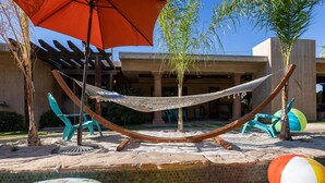 A hammock, outdoor chairs, a pool, and inflatable toys. - Desert Dunes | Lazy River & Water Slide | Swim-Up Bar | Dual Casitas | Sleeps 8 (Palm Springs)