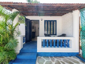 A covered outdoor area with a white wall, a blue railing, and a tiled roof. - Palette Santorini Pool Mountain View (Lonavala)