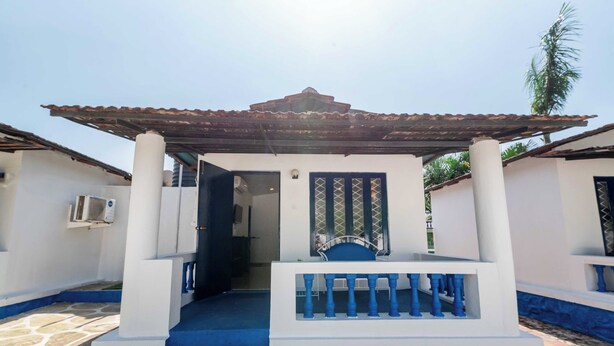 A building with a covered entrance, a staircase, and a door with a decorative grille. - Palette Santorini Pool Mountain View (Lonavala)