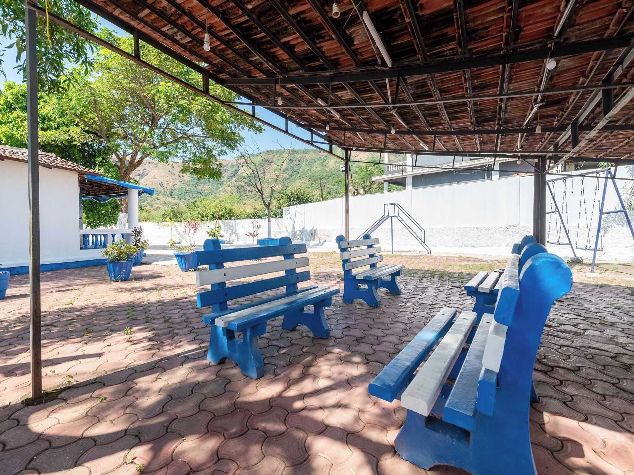 An outdoor seating area with blue benches and potted plants.
