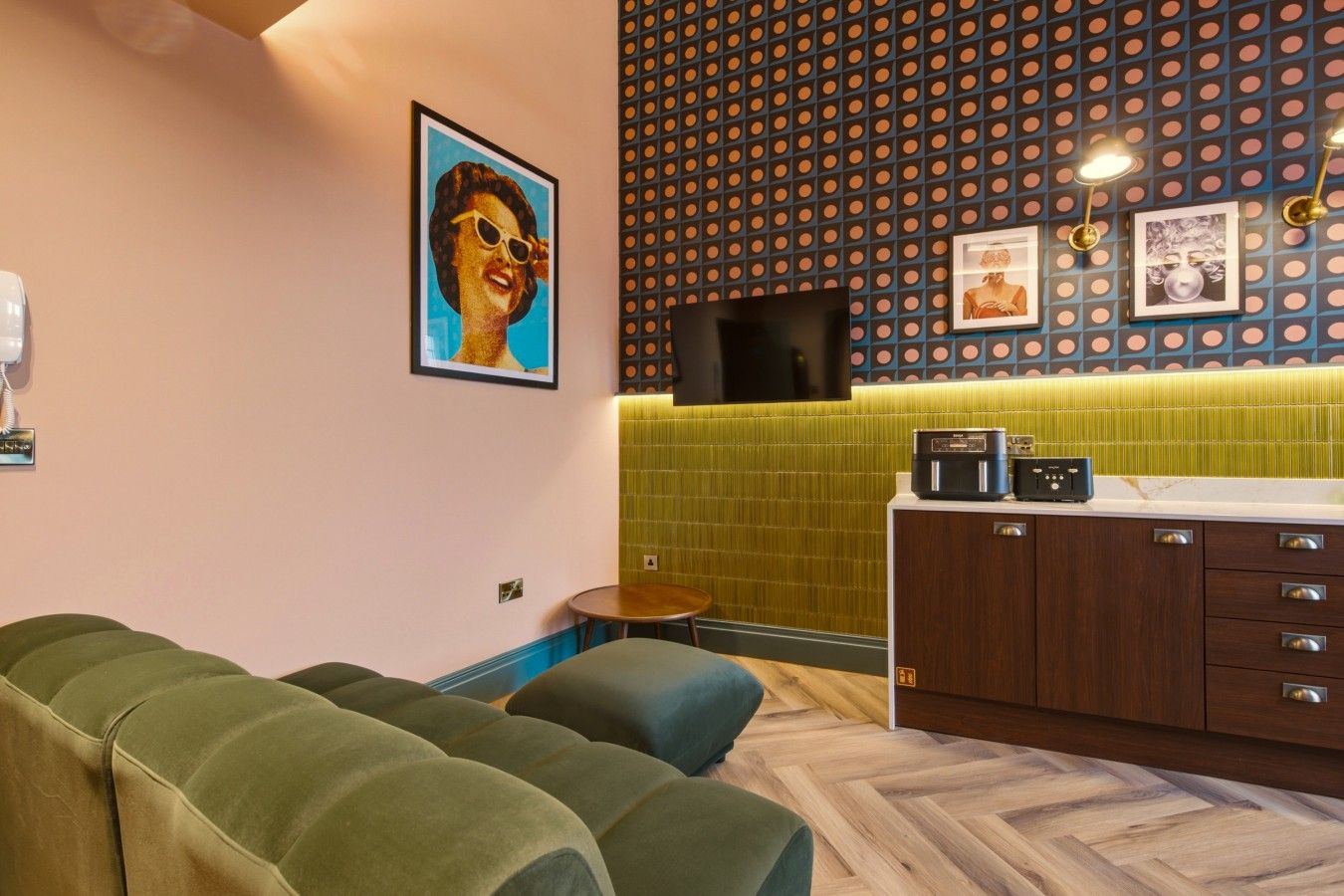 A modern interior with a sofa, a small table, a cabinet with a radio, and a patterned wall.