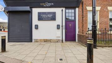 A building with a sign for 'The Four Corner Collective' and a purple door.