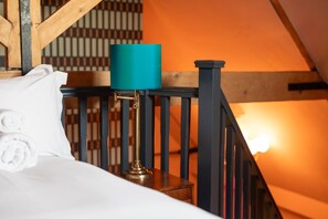 Una camera da letto con un letto, una lampada verde acqua e una scala in legno.