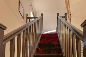 A staircase with wooden railings and a red carpet. - The Loft - The Four Corner Collective (Sunderland)
