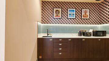 A modern kitchen with a patterned backsplash, a built-in microwave, and a countertop with various appliances.