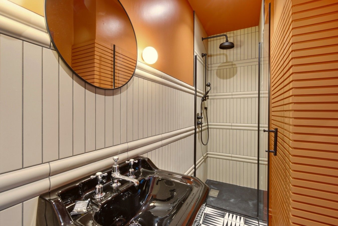 A bathroom with a vanity, a mirror, a shower, and a towel rack.
