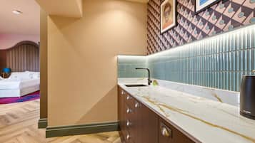 A modern bathroom with a marble countertop, a sink, and a wall-mounted mirror.