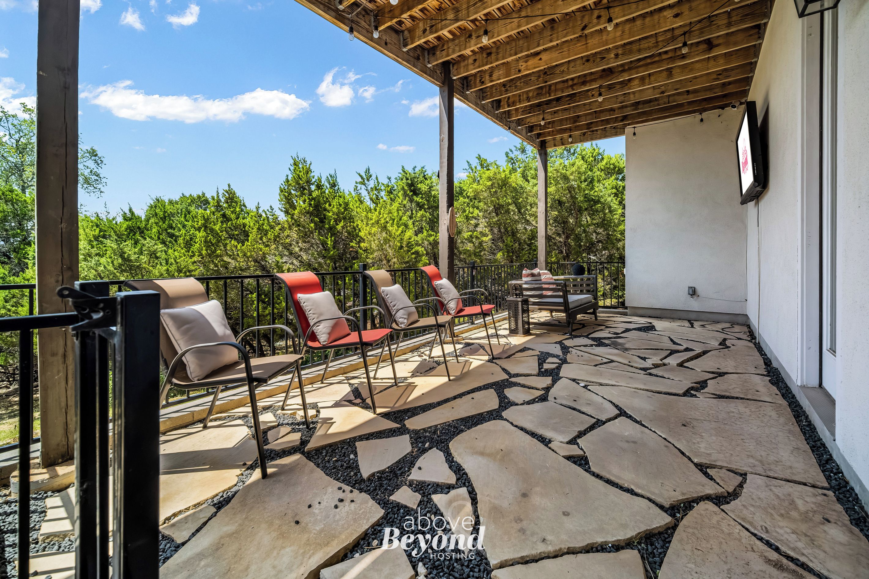 A covered patio with outdoor seating and a stone floor.