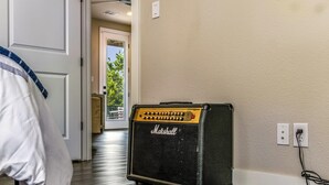 Ett rum med en Marshall-förstärkare, en dörr som leder ut till en balkong och en vit vägg med ett eluttag.