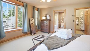 A hotel room with a bed, a ceiling fan, a dresser, a mirror, and a window with curtains. - Olive Street Carriage House | Sleeps 8, Norwalk (Norwalk)