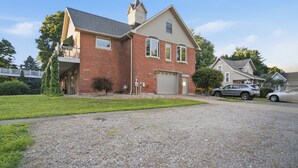 A two-story house with a garage, a driveway, and a small front yard. - Olive Street Carriage House | Sleeps 8, Norwalk (Norwalk)