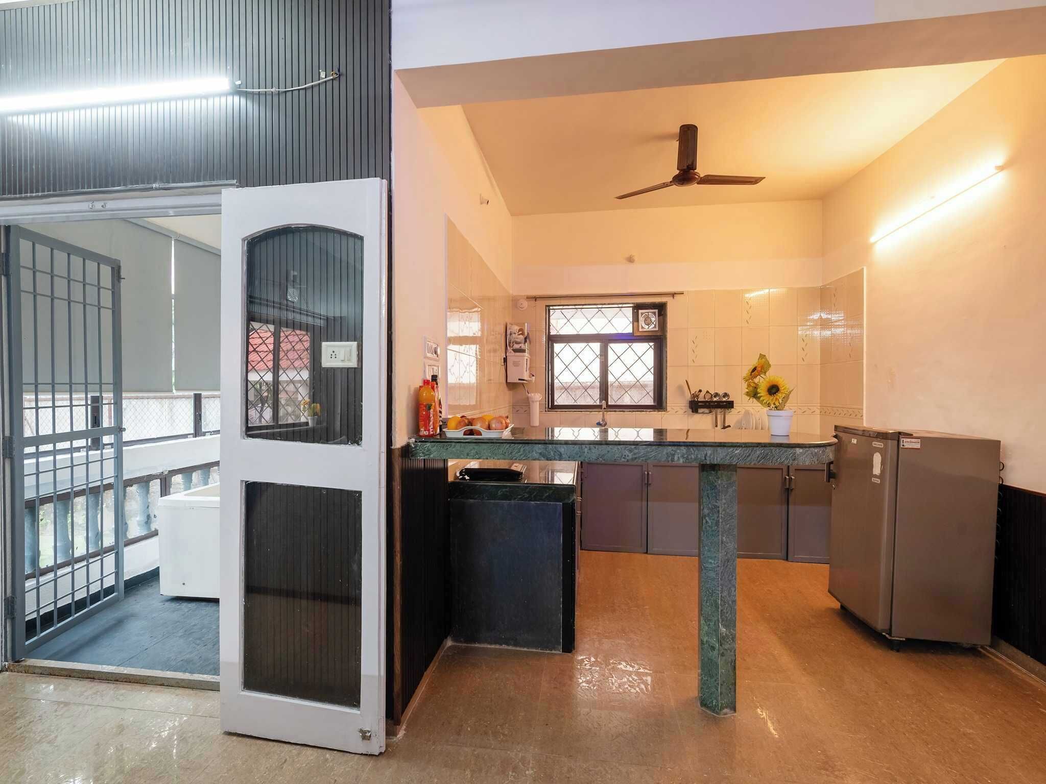 Une cuisine moderne dotée d’un îlot central, d’un réfrigérateur et d’un ventilateur de plafond.