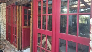 Un edificio con ventanas de marco rojo y una pared de piedra.