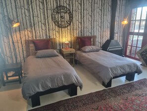 A room with two beds, a clock, a fireplace, and a window. - Room-accessible West Coast Villa Room wi (Langebaan)