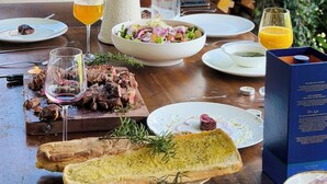 Una mesa de comedor con diversos alimentos, una chimenea y vista a zonas verdes.