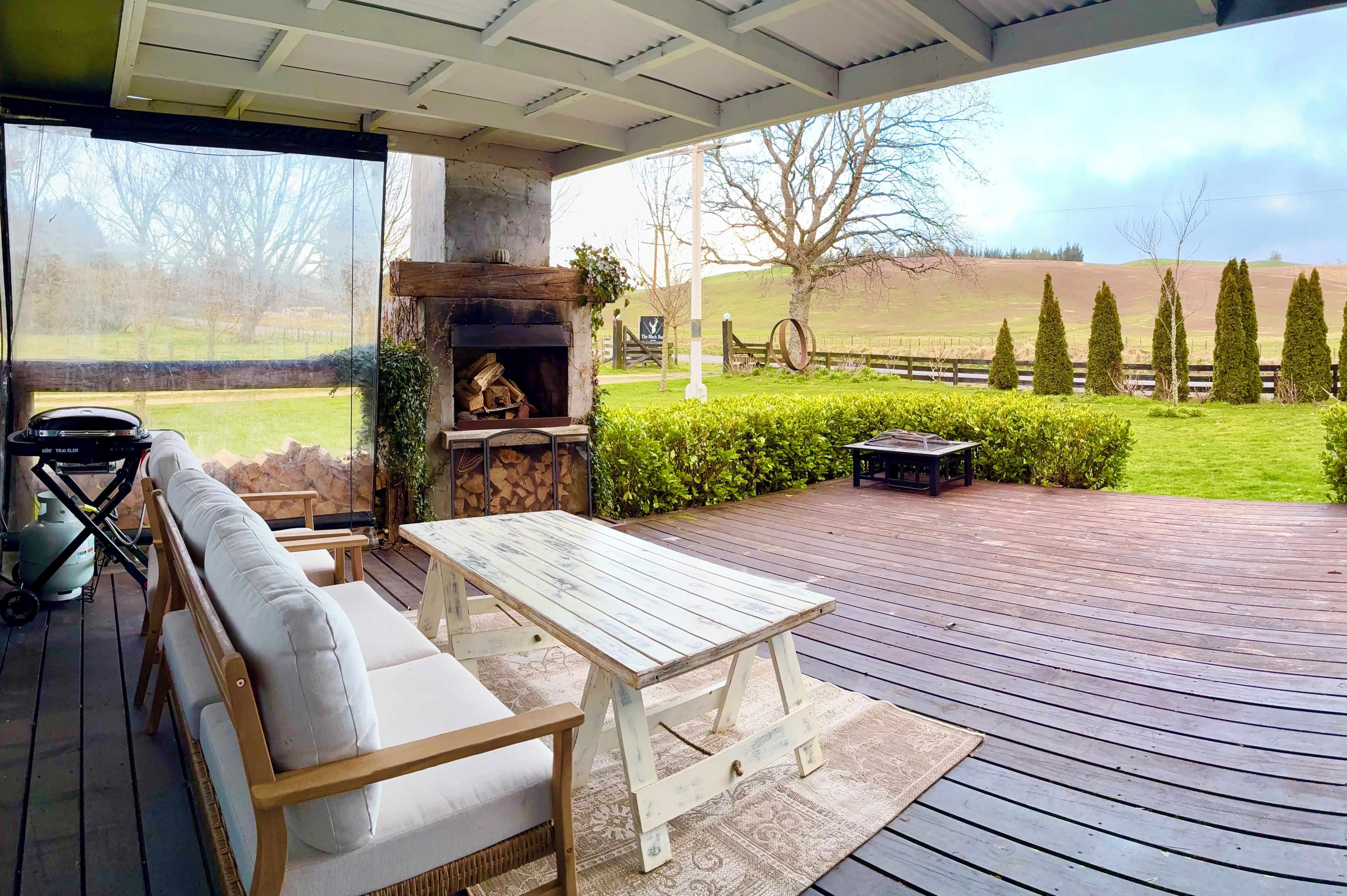 Un patio al aire libre con chimenea de piedra, un sofá y una mesa.