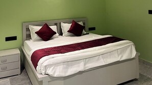 A bedroom with a bed, a ceiling fan, and a nightstand.