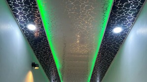 A hallway with a textured ceiling, recessed lighting, and a visible door at the end.
