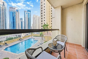 A balcony with a view of a swimming pool and high-rise buildings. - Bloomfields 3br in Rimal 4 JBR (Dubai)