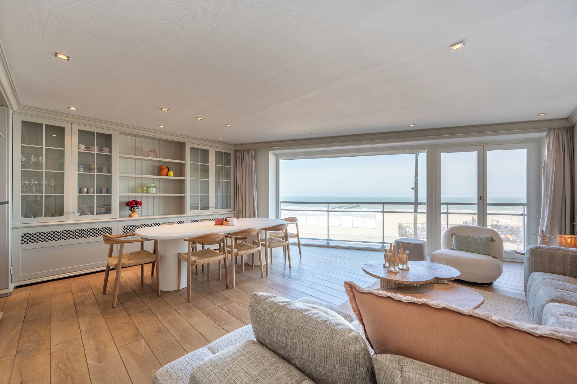 Une pièce spacieuse avec une grande table à manger, un canapé et une vue sur la mer.