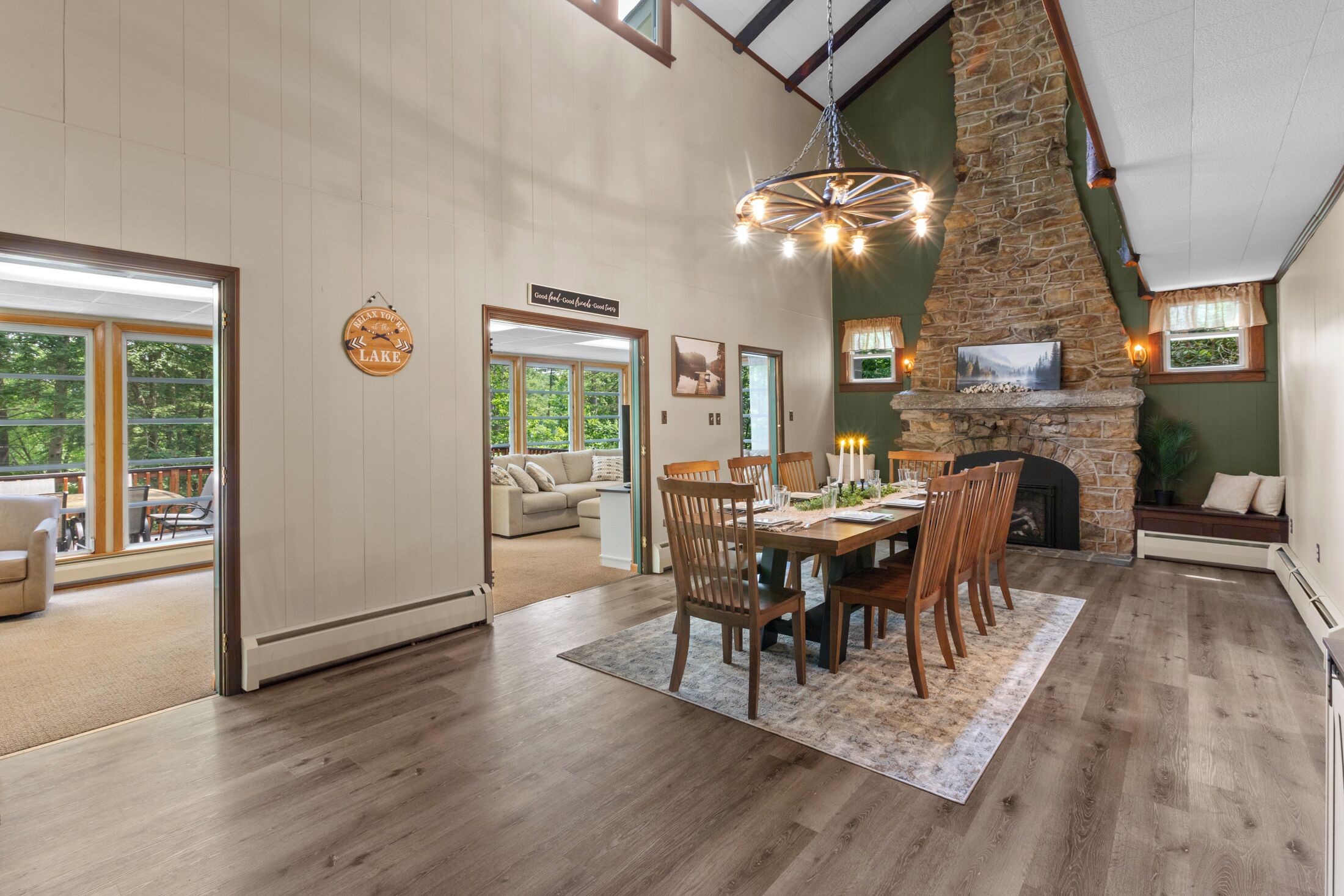 A spacious dining area with a stone fireplace, wooden dining table, and chairs.