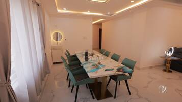 Un comedor moderno con suelo de mármol, un espejo redondo y una mesa preparada para seis comensales.