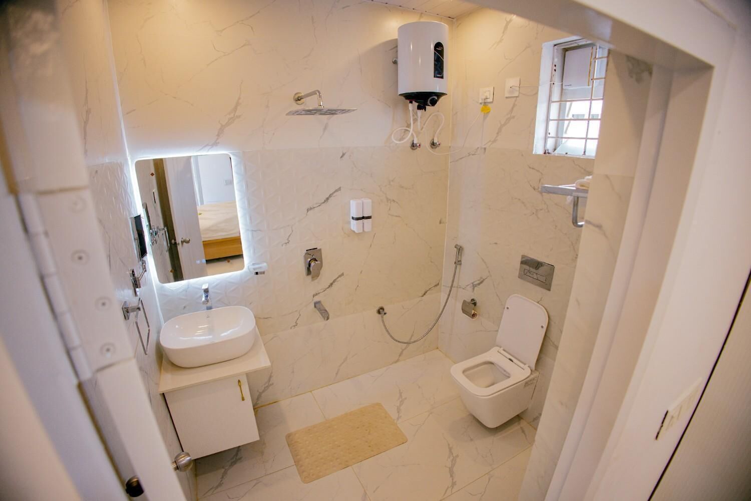 A bathroom with a toilet, sink, shower, and a water heater.