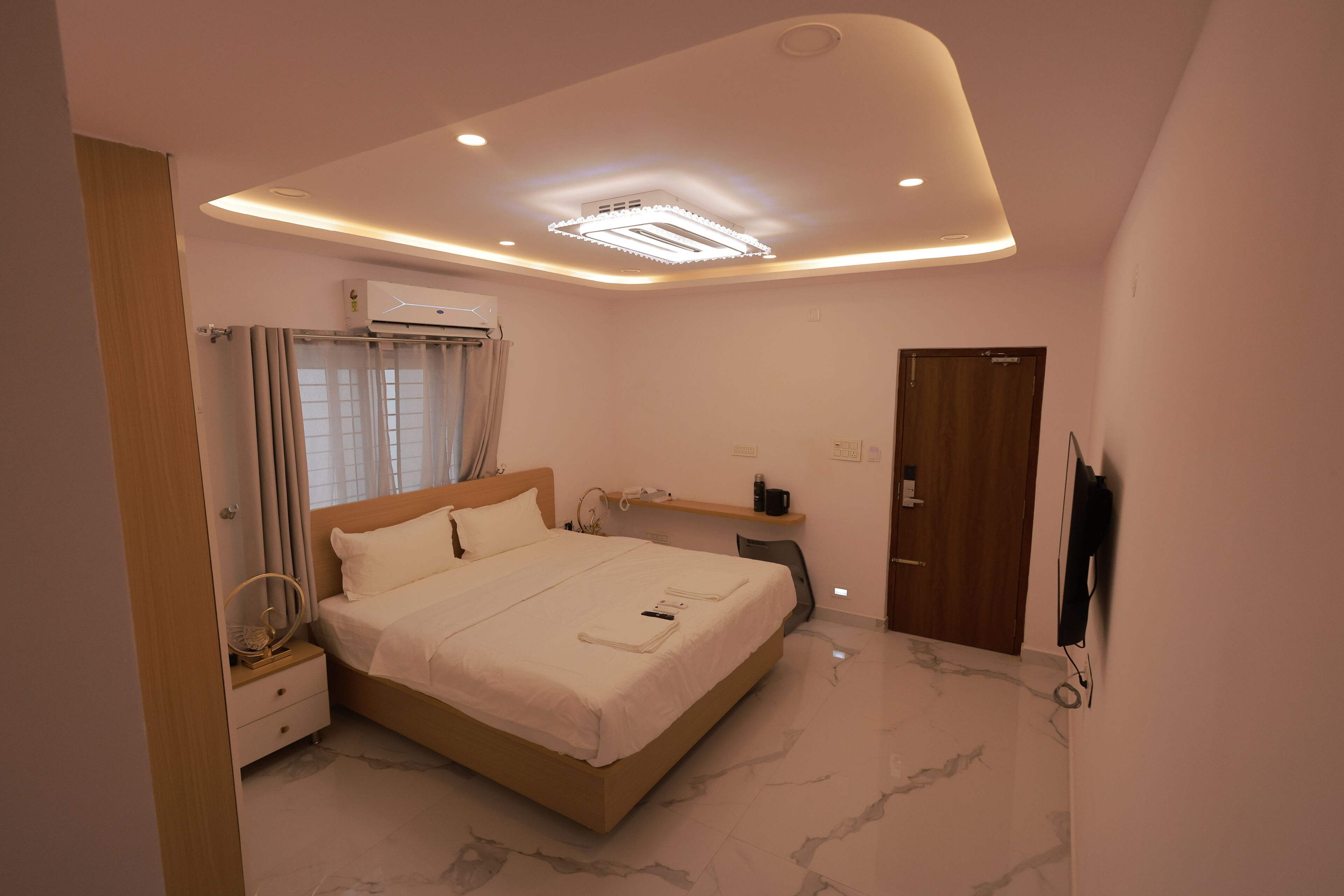 Un dormitorio moderno con cama, mesita de noche y escritorio con silla.