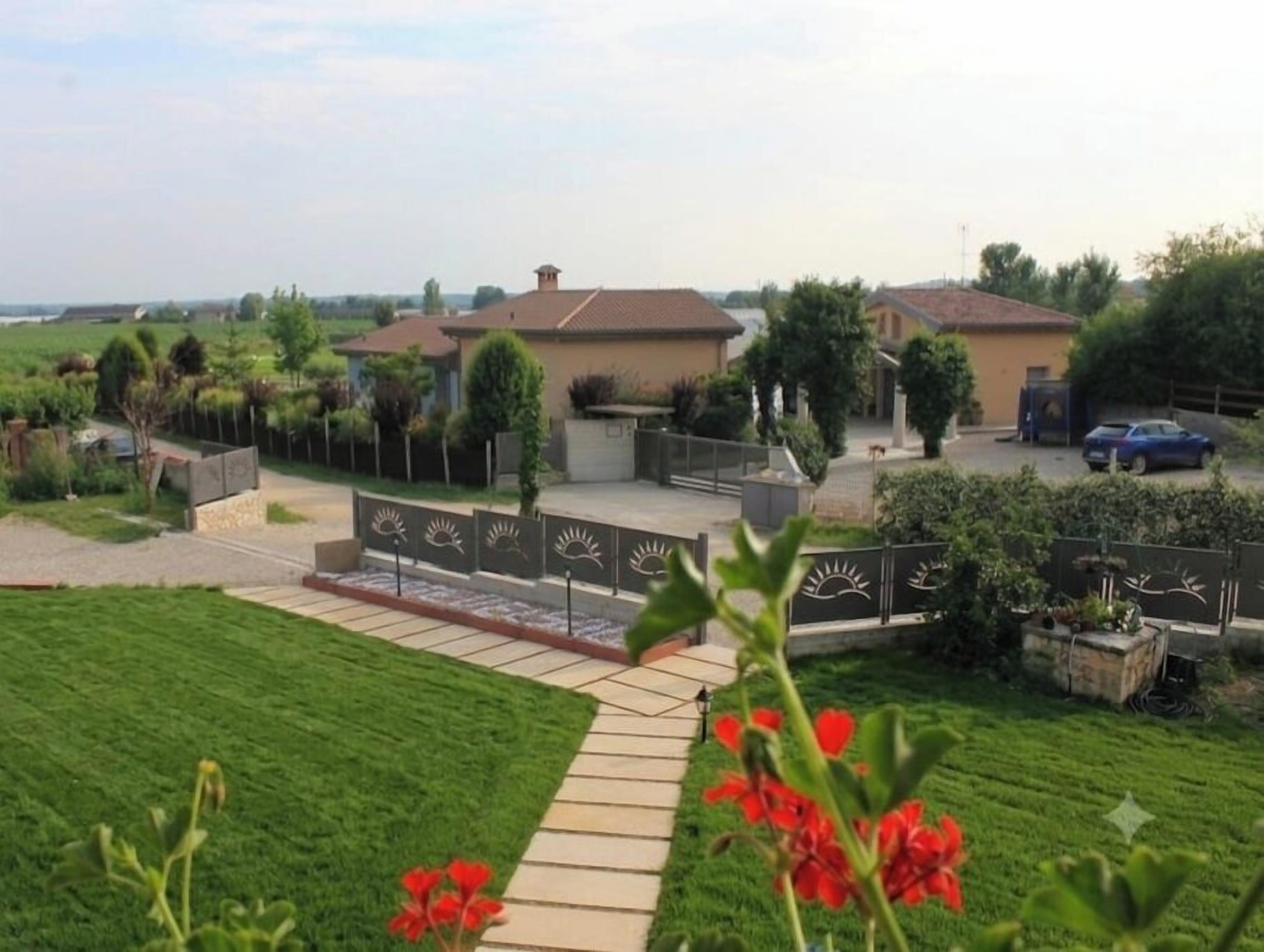 A residential area with a paved walkway, a house with a tiled roof, and a parked car.