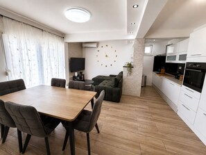 Un espace de vie moderne comprenant un coin repas, un canapé, une cuisine et un mur décoré de chiffres.