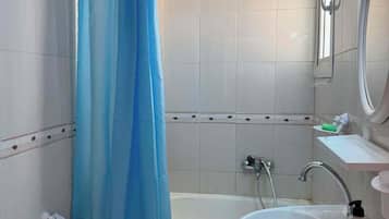 Un bagno con una vasca, un lavandino, un water e una tenda da doccia.