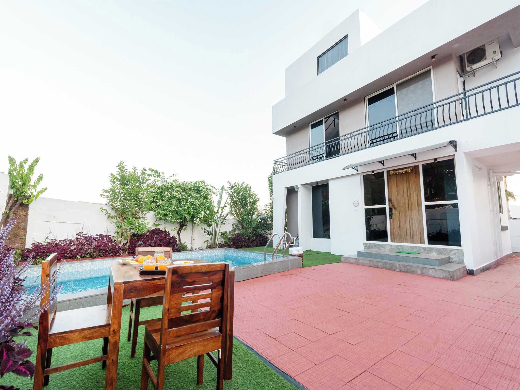 Een modern huis met twee verdiepingen, een zwembad, terras en een balkon.