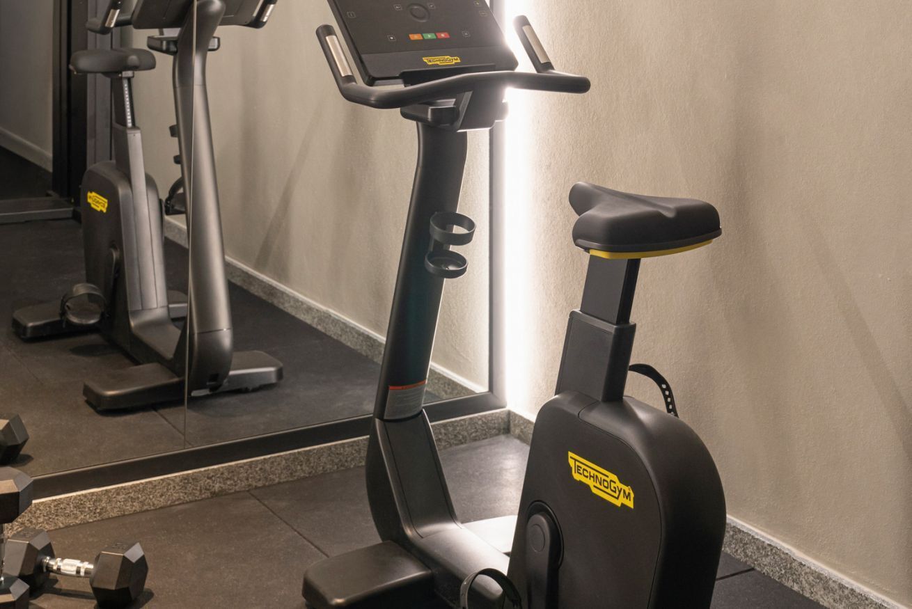 A gym with exercise equipment including a stationary bike and dumbbells.