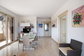 Ein zeitgemäßer Wohnraum mit Essbereich, einer Couch und Kunstwerken an den Wänden.