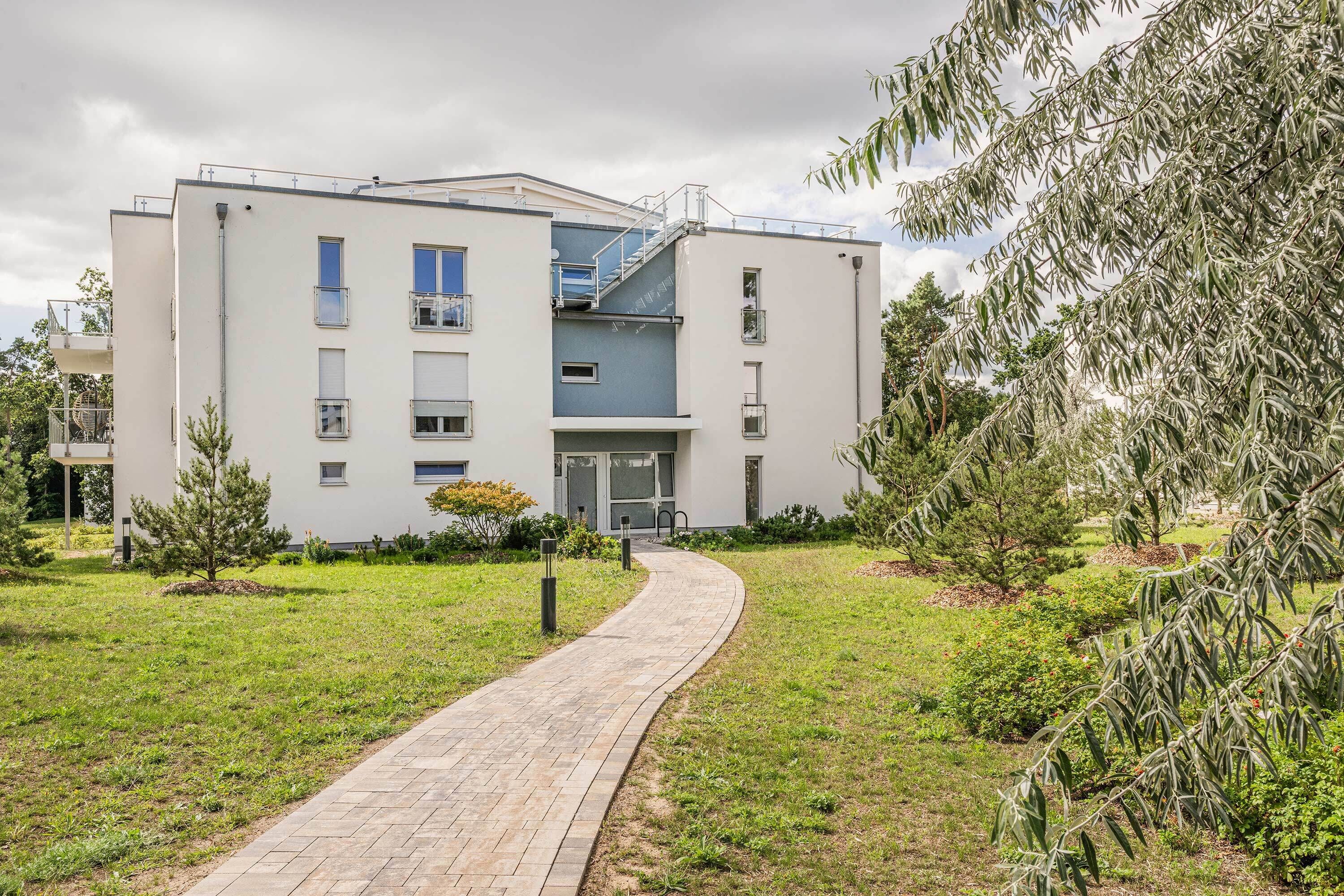 A modern building with a paved pathway leading to the entrance.
