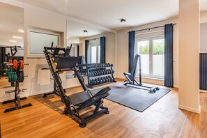 A home gym with exercise equipment, including a bench press, dumbbells, and a pull-up bar. - Modern Labiland vacation rental on the lagoon with a terrace and a magnificent view (Zirchow)