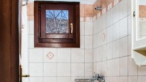 A bathroom with a toilet, shower, and a window above the sink. - Erofili Hotel -  Double Room with Panoramic View (Portaria)