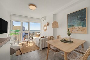 Een modern interieur met een eethoek, een bed en een balkon met uitzicht.