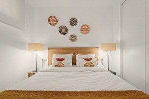 Ein Hotelzimmer mit einem großen Bett, zwei Nachttischlampen, einem Holzkopfteil und Wanddekoration.