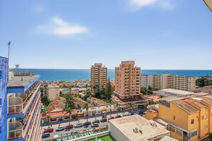 Eine Küstenstadt mit Hochhäusern, blauem Himmel und Blick auf das Meer.