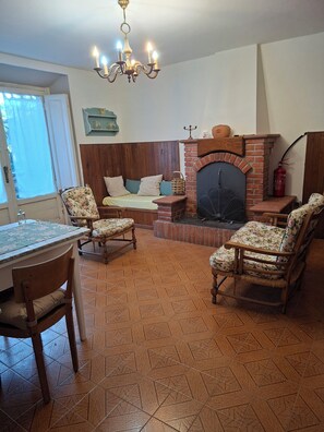 Ein Wohnzimmer mit Kamin, Holzmöbeln und einer Kristallleuchter.
