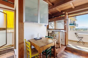 Interior de madera con una mesa de comedor, sillas, un ventanal y vistas al exterior.