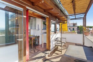A residential property with a wooden exterior, a balcony, and a kitchen area. - Cozy Studio Near Rome Center and Transport with View (Rome)