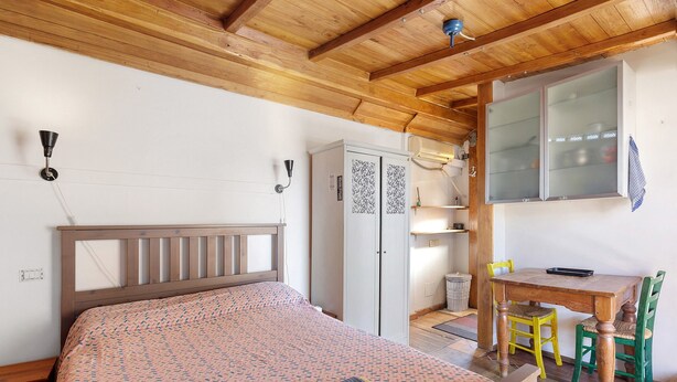 Una camera da letto con un letto, un armadio, una scrivania e una sedia.