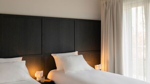 A hotel room with a large bed, two bedside tables with lamps, a dark headboard, and a window with curtains. - MC Lago - My Home in Como (Tremezzo)