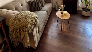 A living room with a sofa, a small round table with a candle, and a potted plant. - "Lerosa Aaluna" Old Town Boutique Apartment, Sleeps 6 (Sibiu)