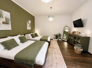 Ein Schlafzimmer mit zwei Betten, einem Fernseher, einer Chandelier und einem Schrank mit Dekorationen.