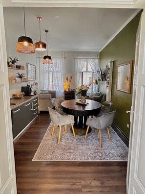A dining area with a round table, chairs, and a rug. - "Lerosa Aaluna" Old Town Boutique Apartment, Sleeps 6 (Sibiu)