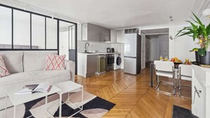 Een modern appartement met een keuken, eethoek en woonkamer.