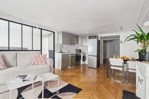 A modern apartment with a kitchen, dining area, and living room. - Charming 1BR near Louvre & Tuileries (Paris)